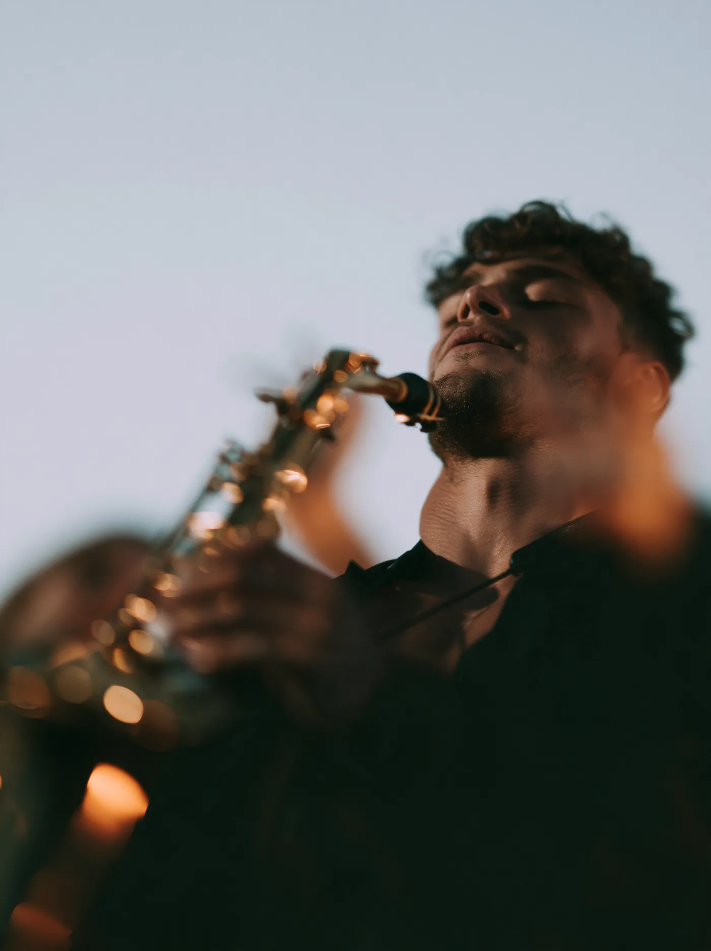 A saxophone player with eyes closed, mid phrase