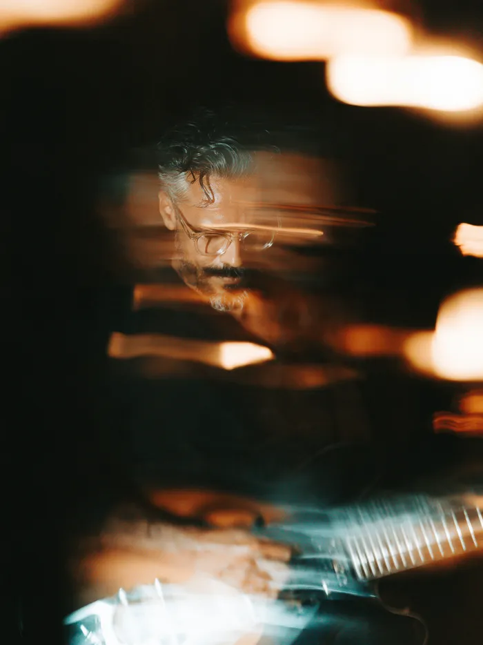 A player in the dark between streaks of stage light